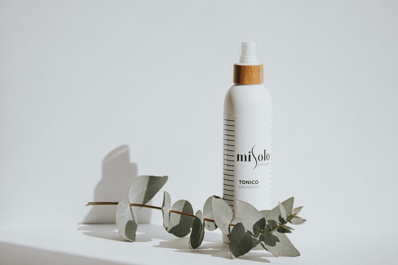 Calming toner bottle with eucalyptus leaves on a white background for skincare branding.